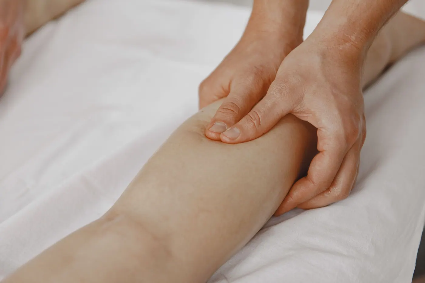 A close view of hands massaging the calf, working the circulation